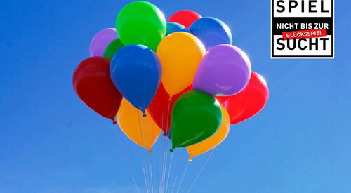 Blauer Himmel ein paar weiße Wolken. Ein Elefant hängt an einem Bund bunter Luftballons. Text: Einfach mal abheben
