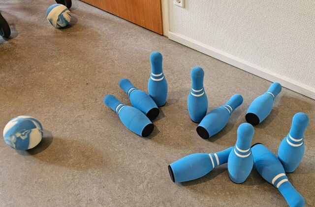 Weiche blaue Kegel und ein blau-weißer Ball auf Teppich.