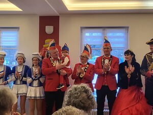 Karnevalisten applaudieren. Mann hat den Nachwuchs auf dem Arm. Karneval begeistert jung und alt.
