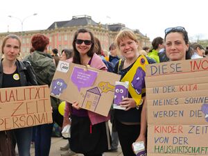 Der Landtag Brandenburg im Hintergrund. 4 Frauen mit Plakaten auf einer Demonstration. Die Frauen halten ihre Plakate in die Kamera und lächeln.