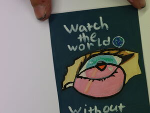 Ein Sticker mit einem Auge und etwas pinken davor. Der Text lautet: Watch the World - with out pink glasses.