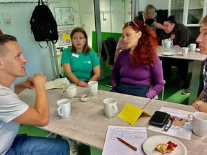 Viehrig sitzt am Tisch mit zwei Frauen und einem Mann im Gespräch.