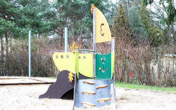 Klettergerüst im Sandkasten, Das Klettergerüst mit kleiner Rutsche sieht aus wie ein Segelboot.