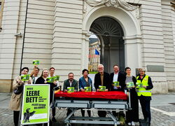 Mit leerem Pflegebett vor dem Landtag