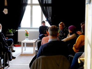 Vorn am Fenster sitzen Frauen. Gespräch / Diskussion.