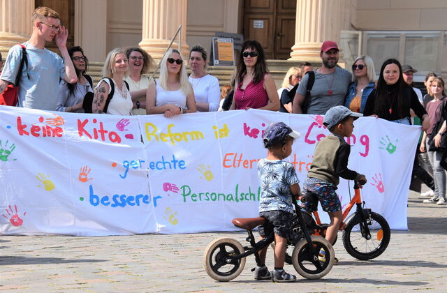 Menschen mit Plakaten bei der Demonstration gegen die Kita-Reform