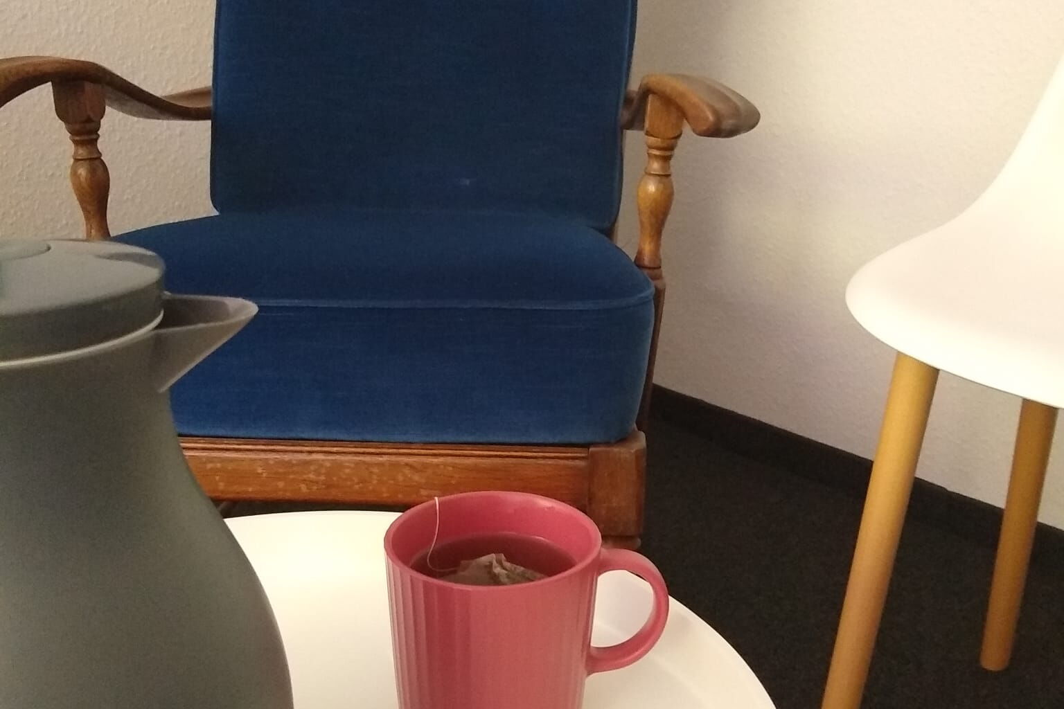 Eine Sitzecke mit einem Sessel und einem runden Tisch
