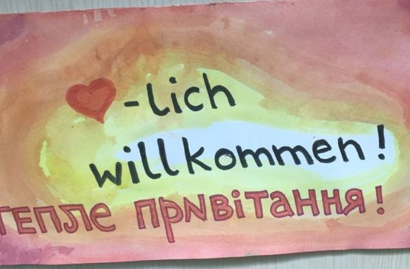Das Foto zeigt ein handgemaltes Plakat, auf dem in Deutsch und Ukrainisch Herzlich Willkommen steht