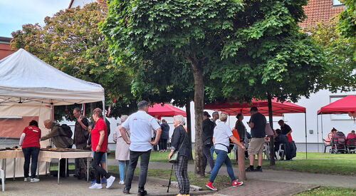 Festszene draußen. AWO Pavillons und Menschen die sich an Ständen informieren.
