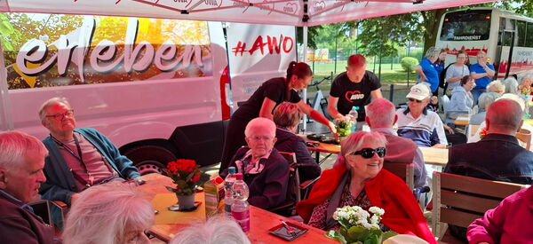 Roter AWO-Pavillon unter dem Senioren sitzen.