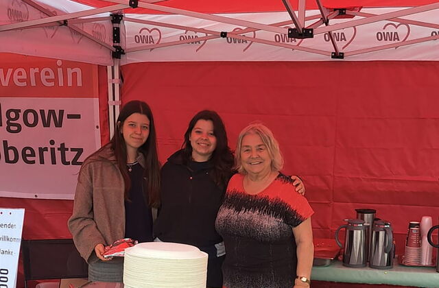 3 Frauen im Stand mit Kuchen und Kaffee.