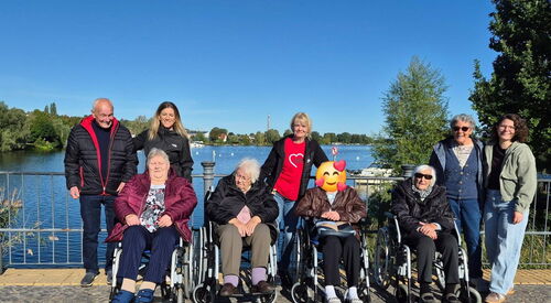 Gruppenfoto: 9 Menschen, darunter vier Seniorinnen im Rollstuhl. Dahinter Senioren und Betreuerinnen stehen dahinter.