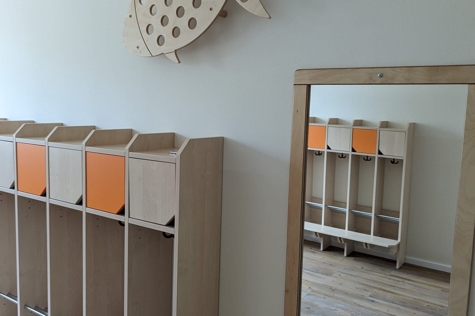 Kinder Garderabe, daneben ein Spiegel an der Wand.