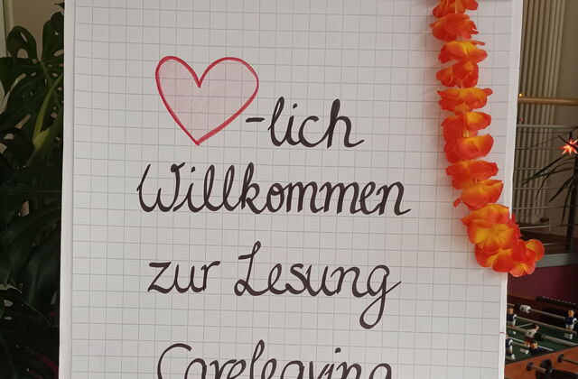 Flipchart. Text: Herzlich willkommen zur Lesung "Careleaving-Storys"