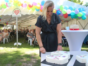 Blonde Frau schneidet Torte an.