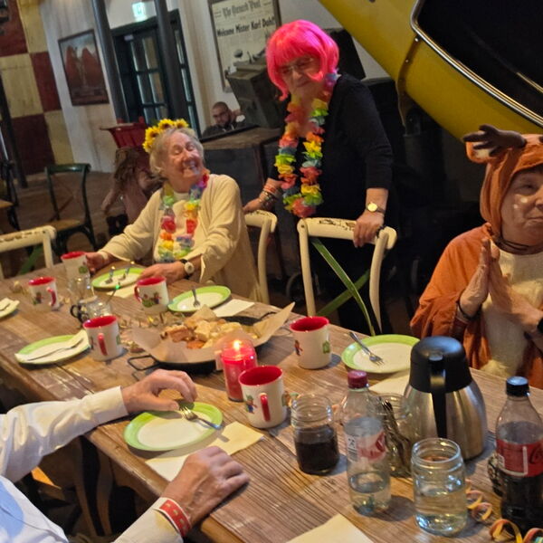 Kaffeetafel in einem Café / Restaurant. Verkleidete Menschen sitzen am Tisch.