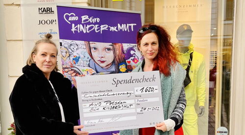 Zwei Frauen halten einen Spendencheck hoch