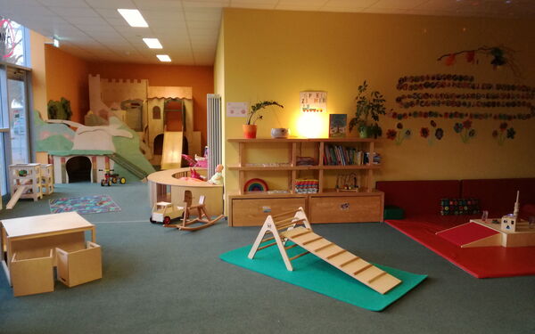 geräumiger Innenraum mit Möbeln und Spielzeug aus hellem Holz