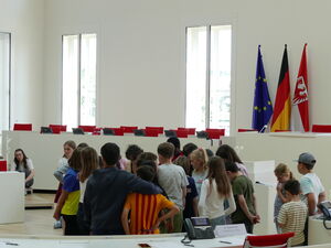 Kinder bilden einen engen Kreis in der Mitte des Plenarsaals.