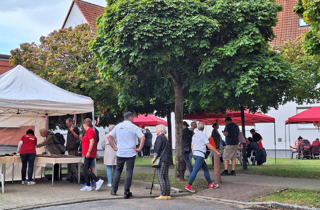Festszene draußen. AWO Pavillons und Menschen die sich an Ständen informieren.