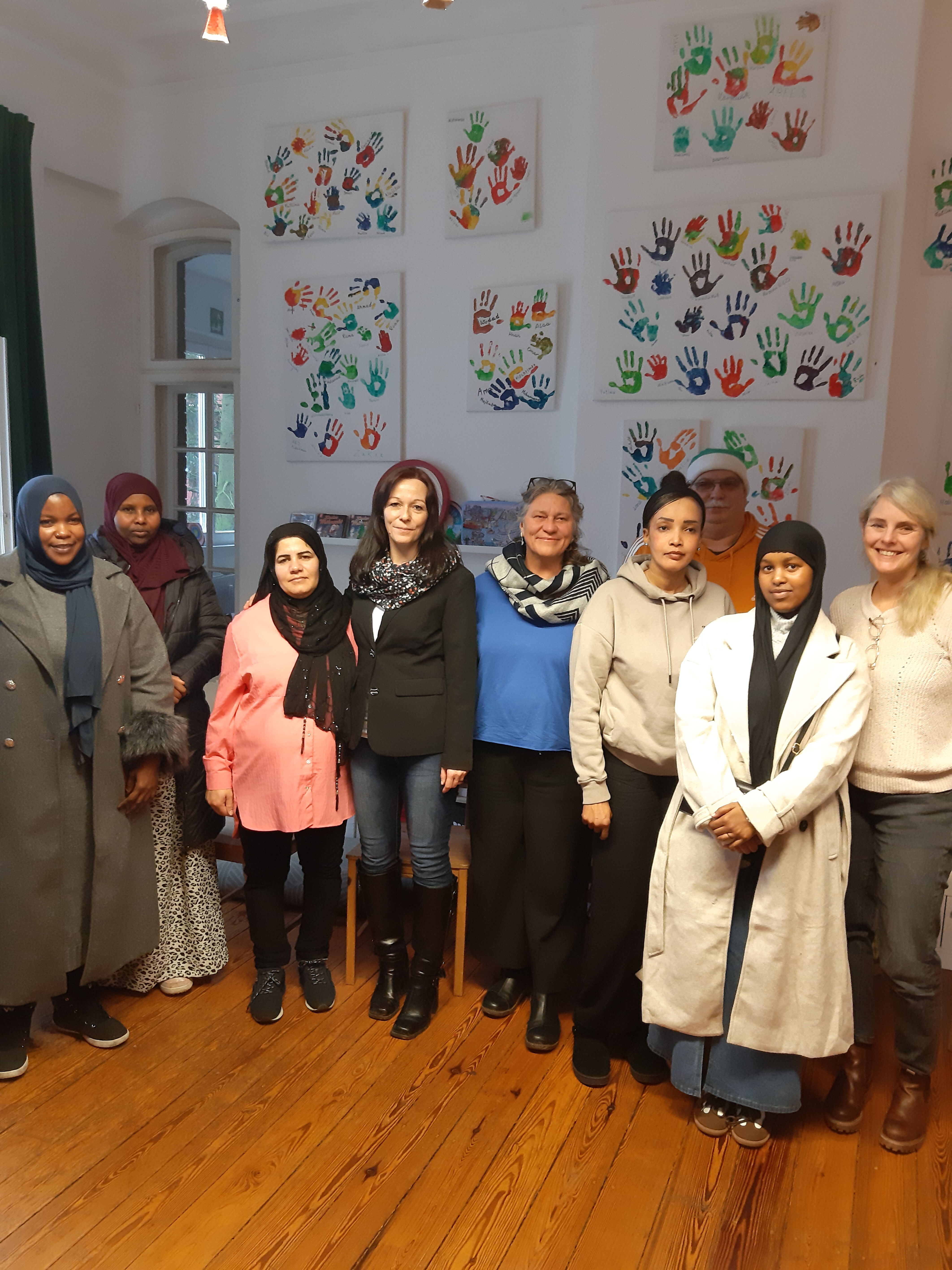 Christin Willnat, Bundestagsabgeordnete von den Linken und Thomas Lotsch vom Kreisverband der Linken im Havelland umringt von Mitarbeitern und Besucherinnen des interkulturellen Familiencafés