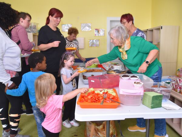 Hier sehen sie Kinder und Erwachsene an einem Buffet