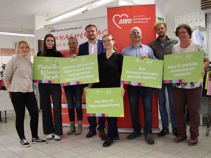 Gruppenbild. 5 Frauen und 3 Männer. Die meisten mit Schildern mit den Forderungen zum Thema Bezahlbarer Wohnraum für alle. Alle lächeln in die Kamera.