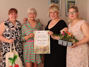 Gruppenbild: 4 Frauen in festlichen und sommerlichen Kleidern. In der Mitte wird der Gutschein über 250 Euro inn die Kamera gehalten.