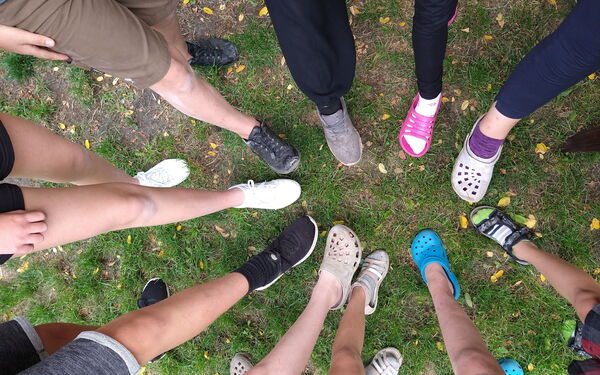 Foto von einer Gruppe die ihre Füsse zu einem Kreis hält
