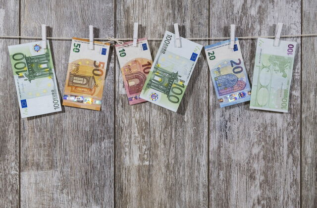 Geldscheine hängen an einer Leine mit Wäscheklammern befestigt. 10 Euro bis 100 Euro Scheine.