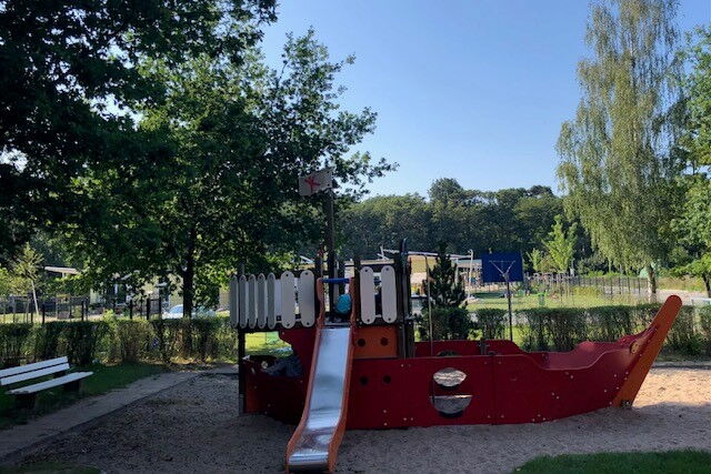 Spielplatz, Klettergerüst mit Rutsche im Sandkasten. Das Klettergerüst sieht aus wie ein Schiff.
