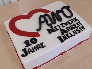 Eine Torte zu 10 Jahren AWO Netzwerk Arbeit Inklusiv steht auf einem Tisch