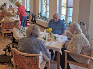 Speisesaal. Ältere Menschen an vierer Tischen.