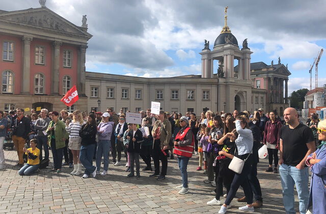 Demonstration. Viele Menschen mit Plakaten und Fahnen, stehen bei schönen Wetter auf dem Alten Markt.
