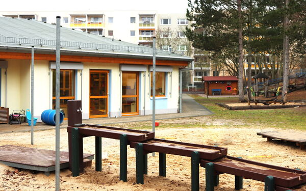 Kita Gebäude mit Spielplatz davor, Wasserspielplatz, Sandkasten.