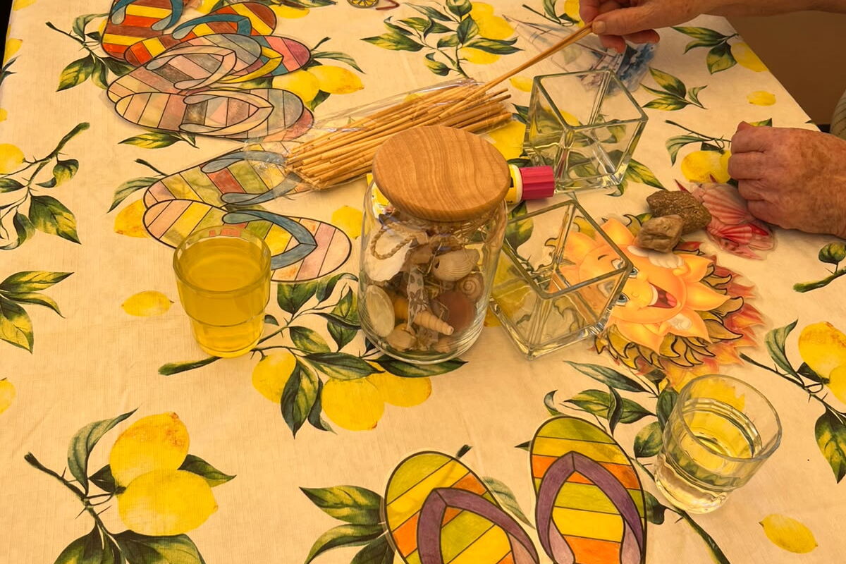 Tisch mit Gläsern, Steinchen und Stäbchen.