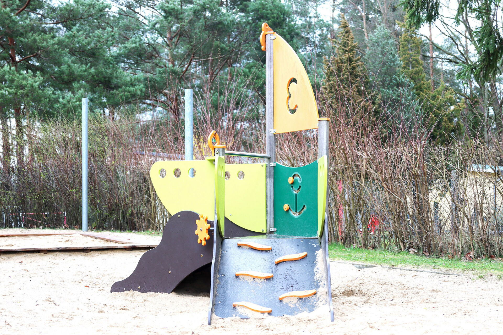 Klettergerüst im Sandkasten, Das Klettergerüst mit kleiner Rutsche sieht aus wie ein Segelboot.