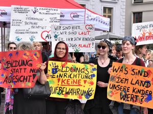 Menschen mit Plakaten bei der Demonstration gegen die Kita-Reform