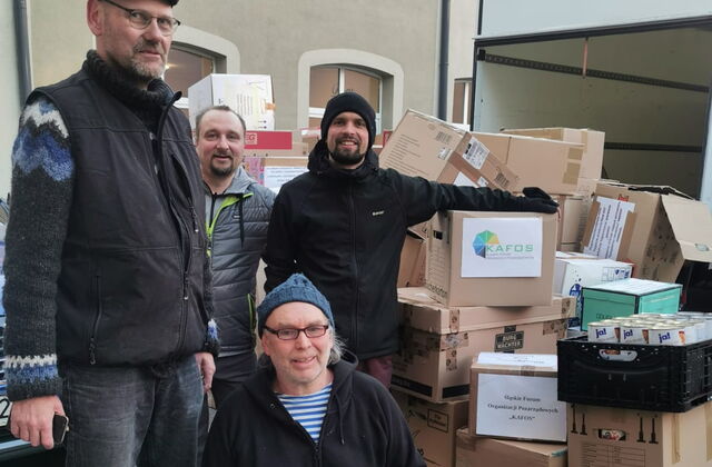 Vier Männer neben einem Stapel Spendenkartons