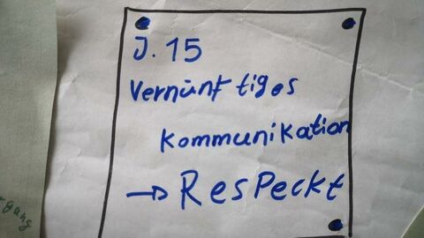 Eine Aufschrift auf einer von Kindern gestalteten Wandtafel