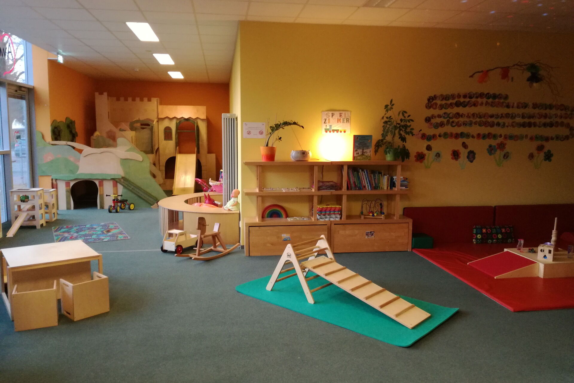 geräumiger Innenraum mit Möbeln und Spielzeug aus hellem Holz