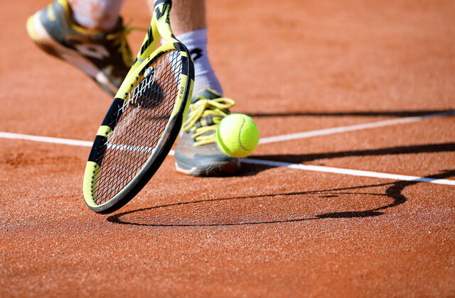 Ein Tennisschläger und eine Tennisball auf einem Tennisplatz