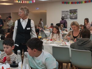 Eltern und Kinder essen gemeinsam in der Kantine.