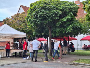 Festszene draußen. AWO Pavillons und Menschen die sich an Ständen informieren.
