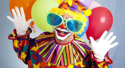 Lustiger Clown mit Hände unterhalb des Kopfes