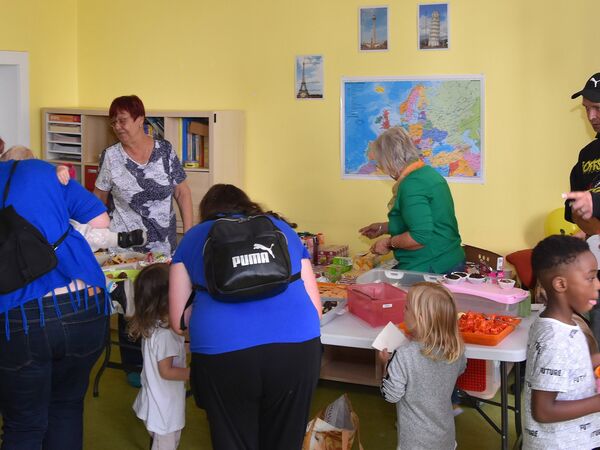 Hier sehen sie Kinder und Erwachsene an einem Buffet