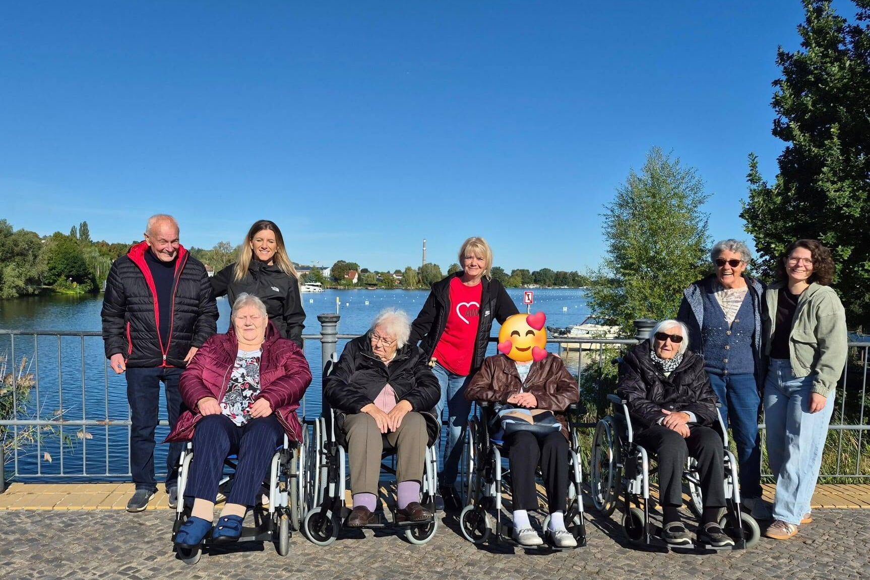 Gruppenfoto: 9 Menschen, darunter vier Seniorinnen im Rollstuhl. Dahinter Senioren und Betreuerinnen stehen dahinter.
