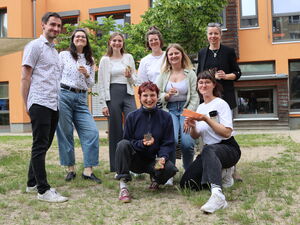 Gruppenbild: ein Mann und 7 Frauen. Draußen. Lockeres, fröhliches Gruppenfoto.