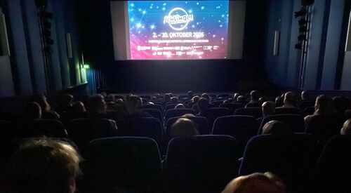 Dunkler Kinosaal. Auf der Leinwand beginnt die Vorstellung.