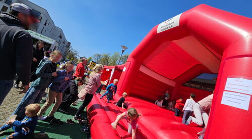Rote Hüpfburg auf der Kinder spielen / toben.